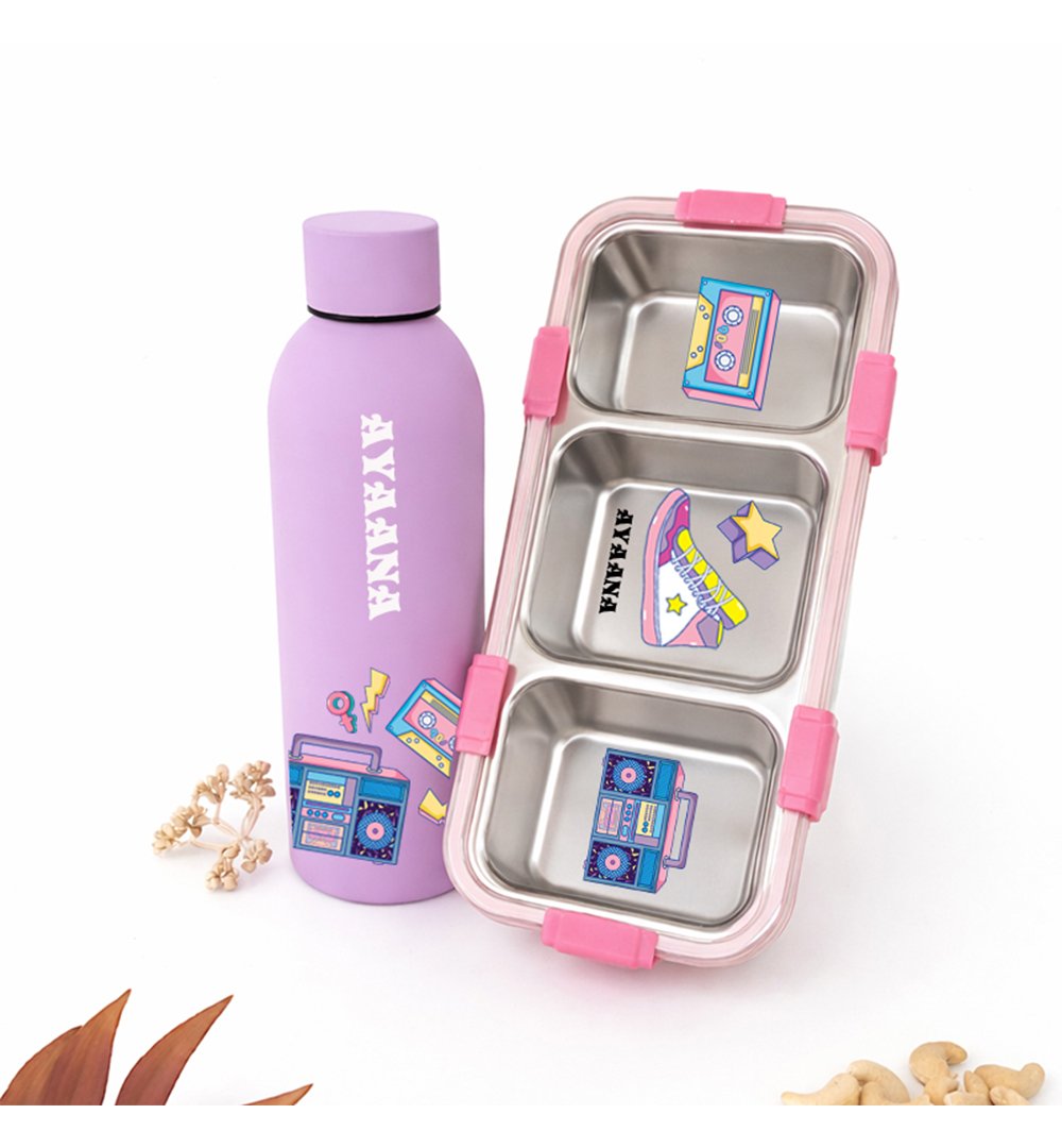Purple insulated water bottle with white vertical text beside a pink, three-compartment lunchbox with colorful stickers.