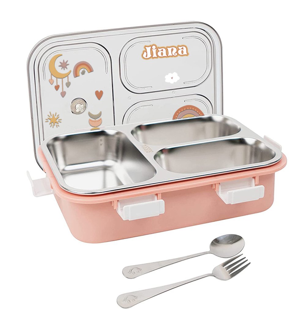 Pink lunch box with two stainless steel compartments and a decorative lid that reads 'Jiana', plus a spoon and fork beside it.