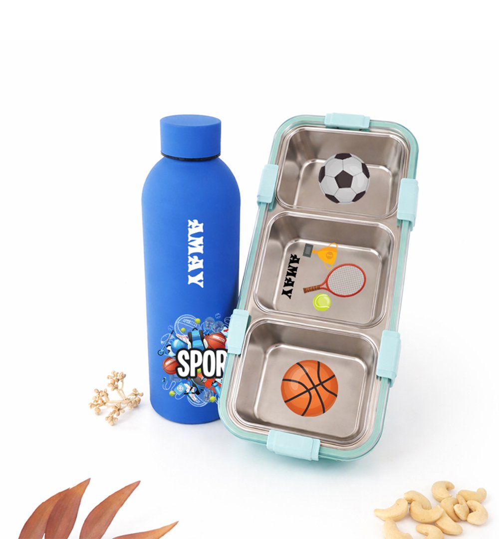 Blue sports water bottle next to a three-compartment lunchbox with soccer ball, tennis racket, and basketball stickers.