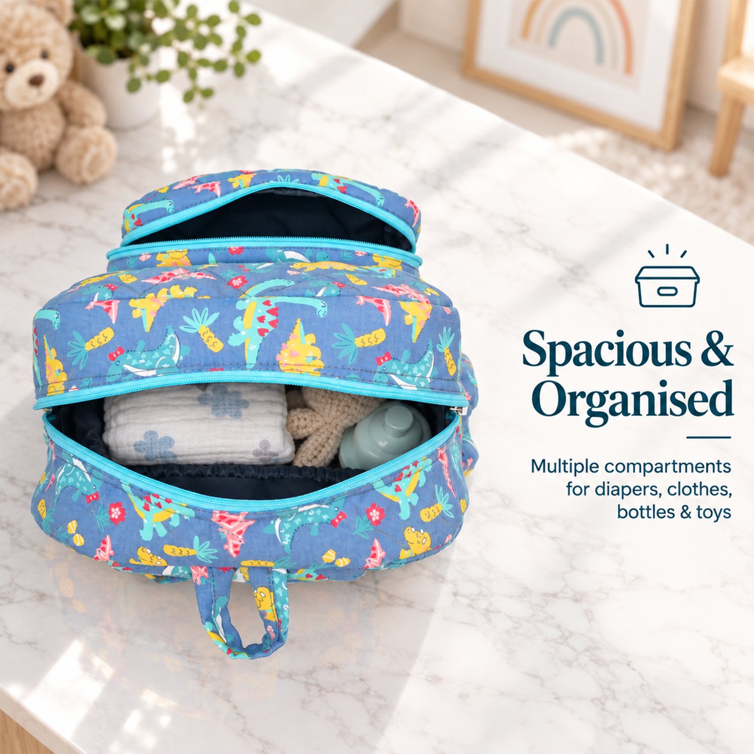 Blue dinosaur-patterned diaper backpack with the top zipper open, showing diapers and a bottle inside on a marble surface.