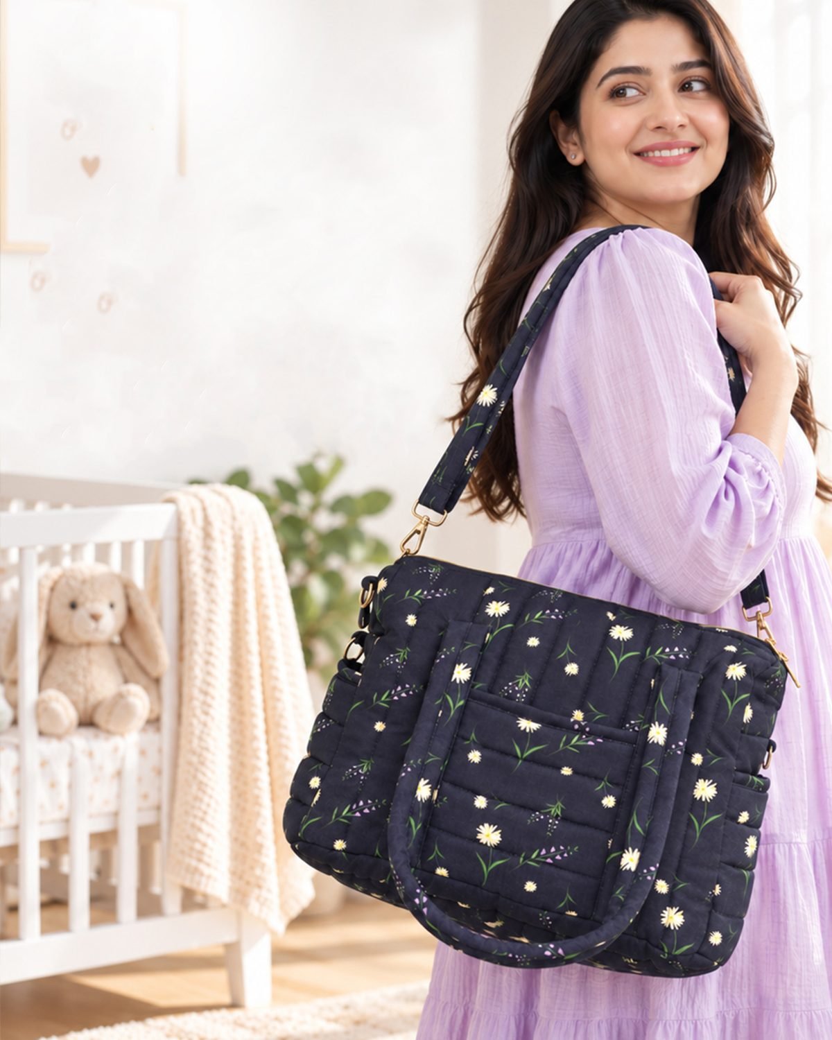 Smiling woman in a lavender dress carries a dark floral tote bag in a bright nursery with a teddy bear and crib in the background.